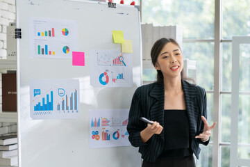 An Asian businessman is presenting his company performance report to his boss or group of male and...