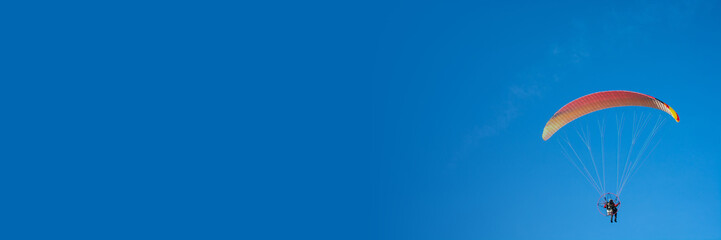 paraglider on a blue background, colorful canopy