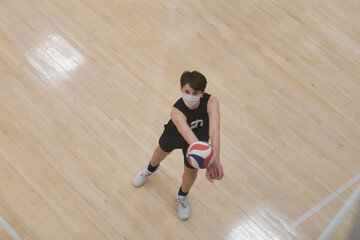 Masked volleyball player passing the ball