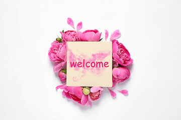 Fresh peonies and card with word WELCOME on white background, top view