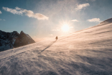 A traveler man mountaineering on snowy mountain among the blizzard in the evening at Mount Ryten