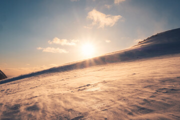 Fototapeta na wymiar Sunset over snowy mountain and windy on Mount Ryten