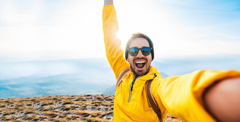 Happy man taking selfie on the top of the mountain - Millenial influencer on social media - Hiker...