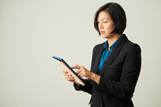 Serious female entrepreneur checking documant on tablet computer