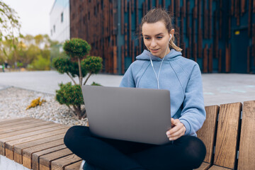 Girl with earphones talking, using webcam.