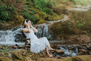 girl sitting on her stomach listening to music in the forest