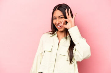 Young hispanic woman isolated on pink background cheerful and confident showing ok gesture.