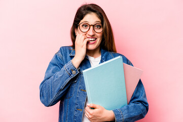 Young student caucasian woman isolated on pink background biting fingernails, nervous and very...
