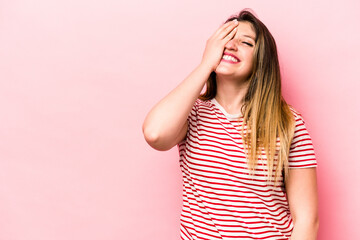Young caucasian woman isolated on pink background laughing happy, carefree, natural emotion.