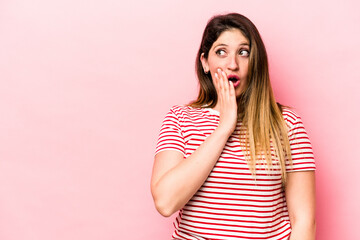 Young caucasian woman isolated on pink background is saying a secret hot braking news and looking aside