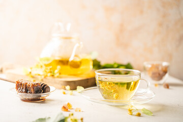 Cup of herbal tea with linden flowers on white background