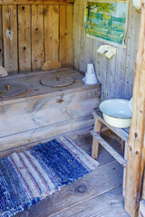 Fototapeta na wymiar Outhouse with a rug on the wooden floor