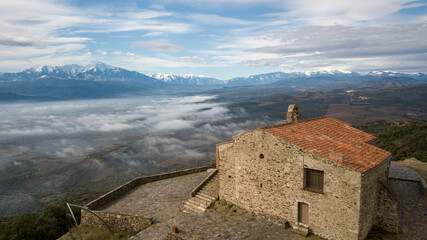 Ermitage de Força Real avec le Canigou enneigé et une mer de nuages