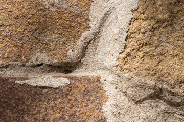 Abstract natural rock stone texture design background. A stone wall. Brown stones. A wall with grey seams. Brick building elements. Background for photos. Rough, cold and rough stones