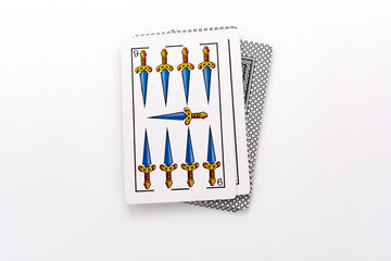 Spanish card game, spanish deck Tarot cards, the swords card in the foreground.