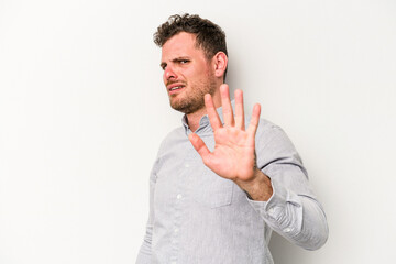 Young caucasian man isolated on white background being shocked due to an imminent danger