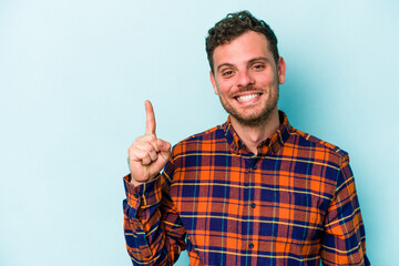 Young caucasian man isolated on blue background showing number one with finger.