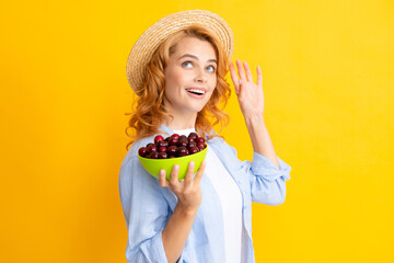 Portrait of woman with cherries on yellow studio isolated background.