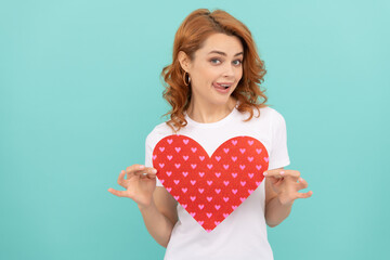 happy redhead lady hold red heart on blue background