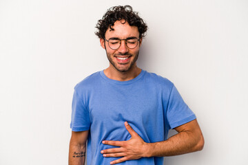 Young caucasian man isolated on white background touches tummy, smiles gently, eating and satisfaction concept.