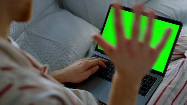 Man talking green laptop resting on sofa closeup. Teacher having online lecture