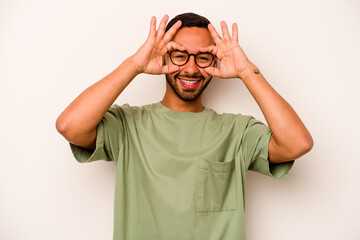 Naklejka premium Young hispanic man isolated on white background excited keeping ok gesture on eye.