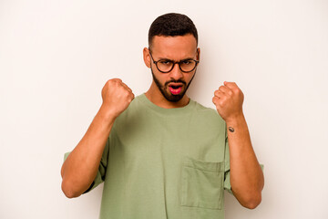 Young hispanic man isolated on white background upset screaming with tense hands.