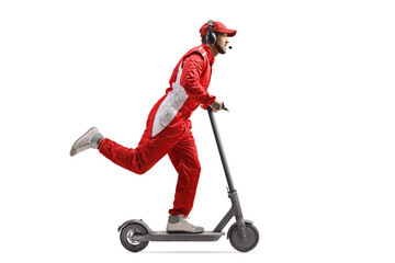Full length profile shot of a racer in a red suit riding an electric scooter
