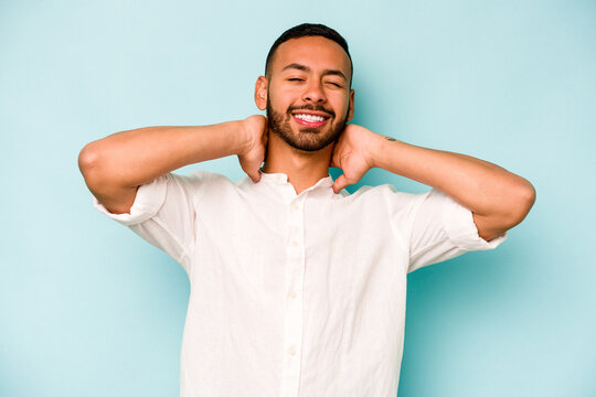 Young hispanic man isolated on blue background suffering neck pain due to sedentary lifestyle.