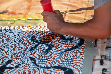 Human hands with painting tools, indigenous street painting at a community event in Australia,...