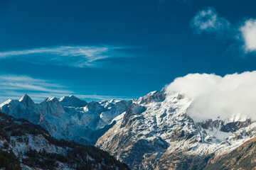 Fototapeta premium Snowed mountain peaks in sunset during spring