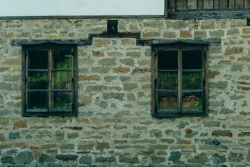 old stone wall with two old wooden windows