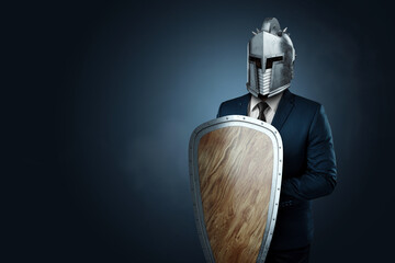 Creative image, a man in a modern suit of a businessman, a knight's helmet on his head, armor. The concept of a modern hero, overcoming difficulties, a crisis, a good manager. magazine style