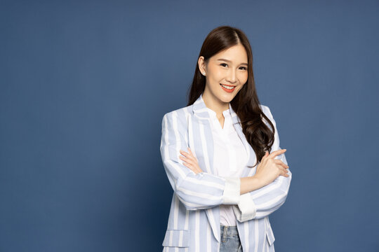 Portrait of successful business asian women in suit with arms crossed and smile isolated over blue background