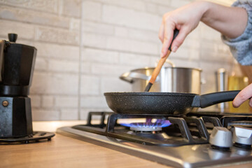 frying pan on cooking top blue flame