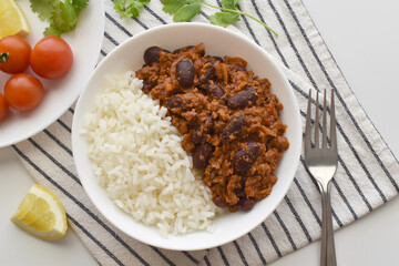 Chilli con carn on a white bowl.  Traditional Mexican food.   Flat lay top view photo.