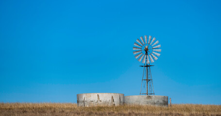 A windmill and two dams on a South African farm.