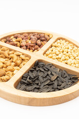 Peanuts cashew sunflower seeds and chickpea in the wooden bowl above white background
