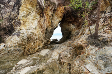 Pierced stone or hole in a massive quartzite rocky cliff.