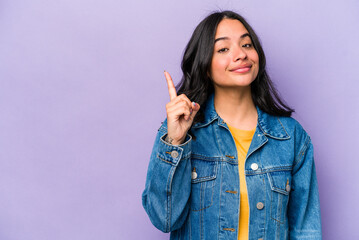 Young hispanic woman isolated on purple background showing number one with finger.