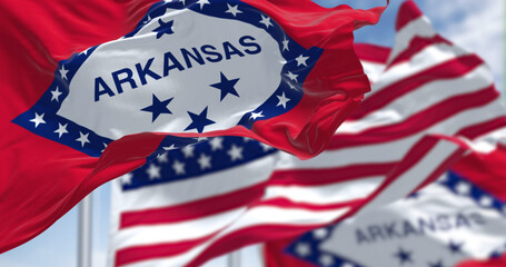 Fototapeta na wymiar The flags of the Arkansas state and United States waving in the wind.