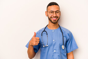 Young hispanic nurse man isolated on white background smiling and raising thumb up