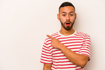 Young hispanic man isolated on white background pointing to the side