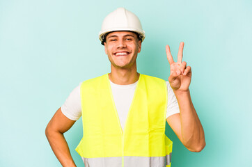 Young laborer caucasian man isolated on blue background showing number two with fingers.