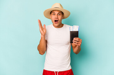 Young caucasian traveler man holding passport isolated on blue background surprised and shocked.
