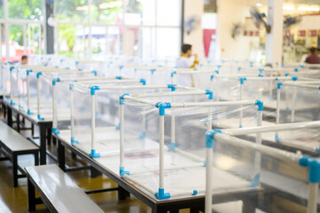 Clear  plastic divider on empty table in food court for Covid-19 protection , New normal, social distancing concept.
