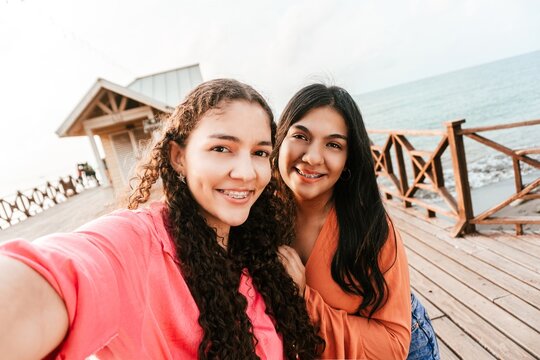 Two friends women with brackets taking a photo in the tourist dock of the city of la Ceiba.