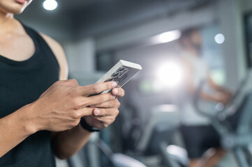 Hands of man use smartphone in fitness during work out