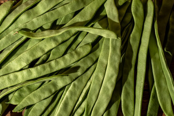 Close-up of fresh green beans (Phaseolus vulgaris) on wooden background.