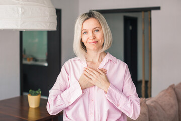 happy adult female volunteer holding folded hands on chest